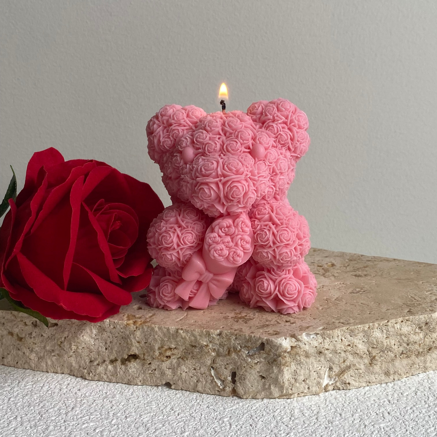 Pink teddy bear-shaped candle with a red rose on a stone surface | Pink Love Bear Sculptural candle
