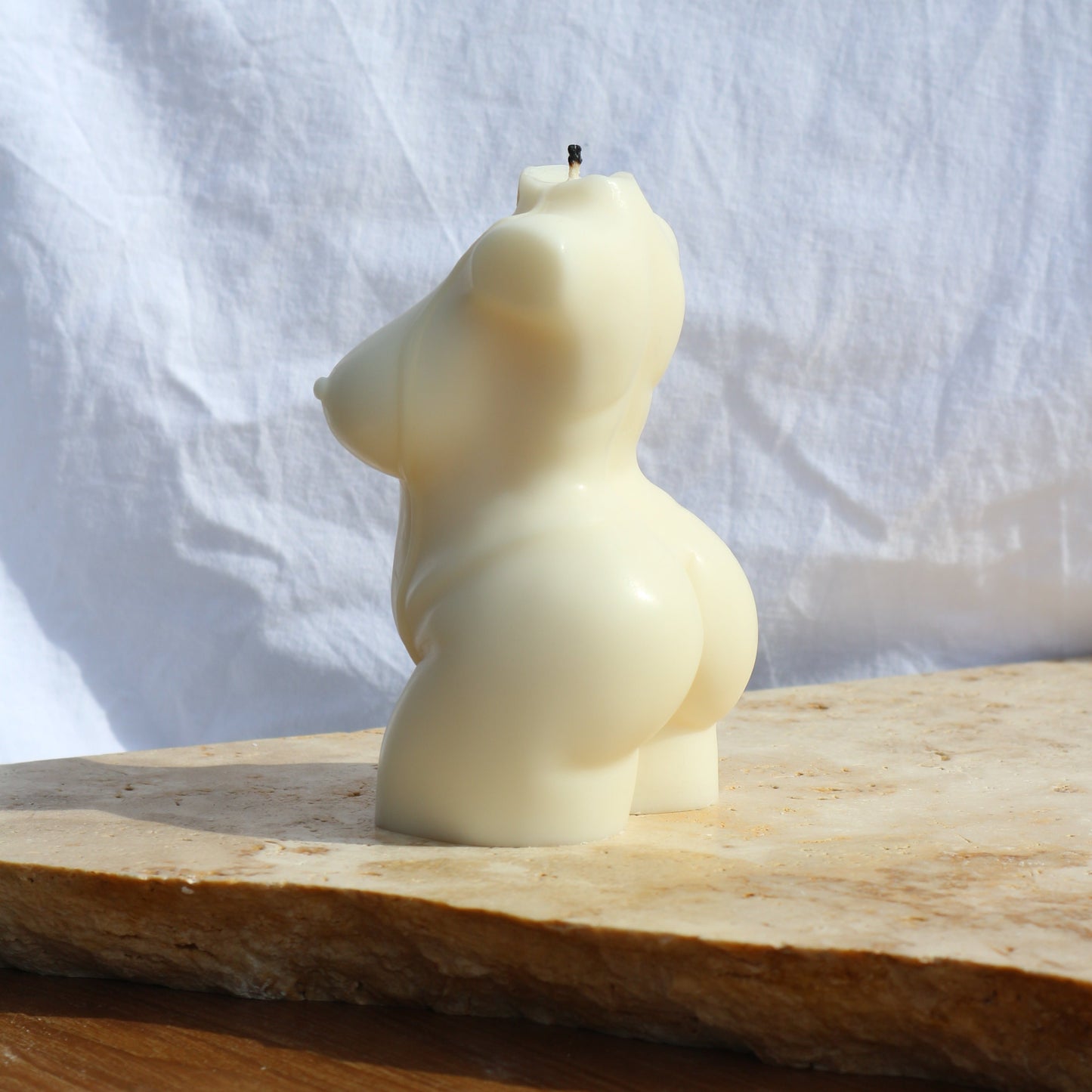Close-up of Peachy female body soy wax candle showing sculptural curves and texture
