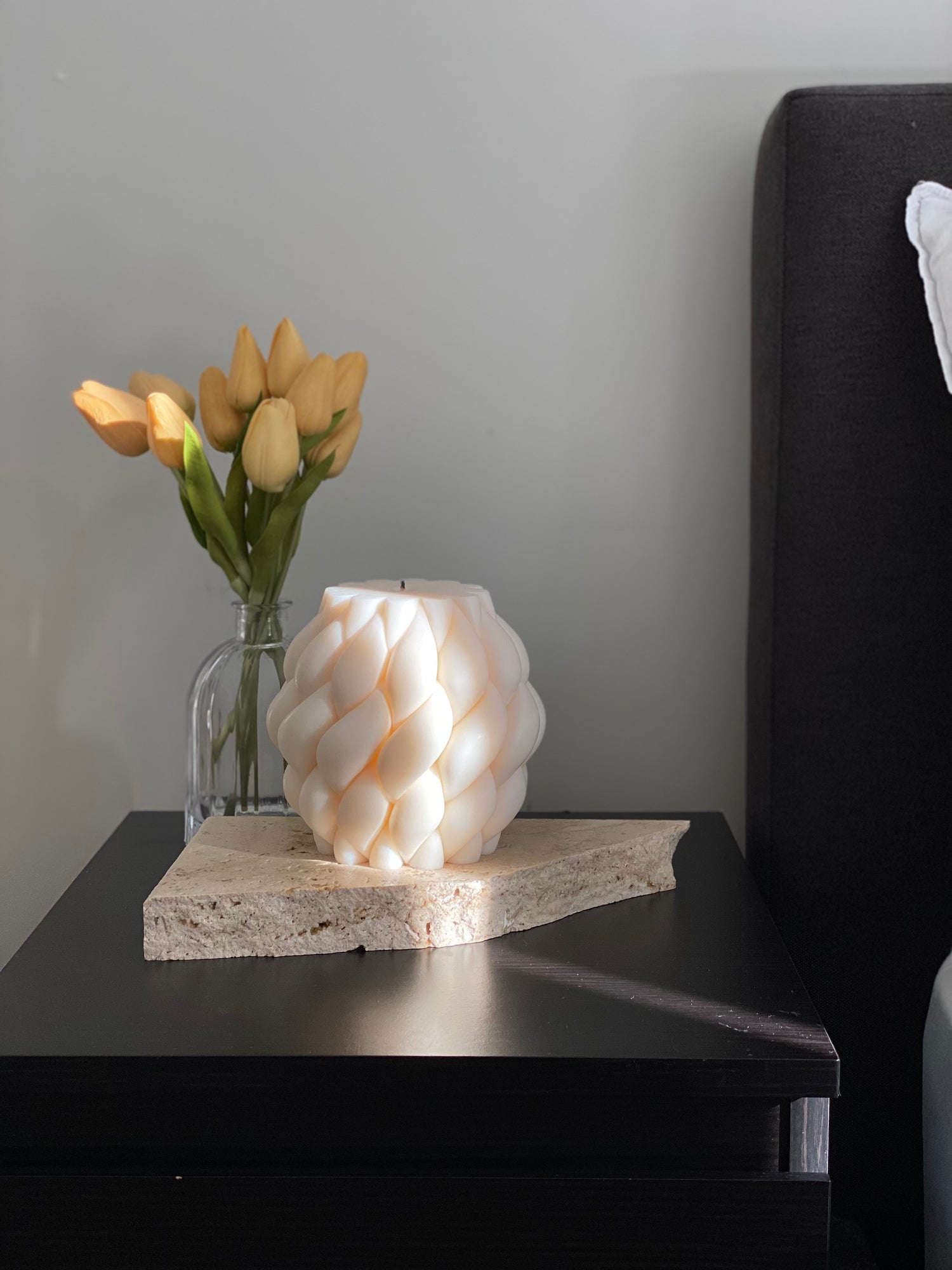 Large sculptural candle styled on a bedside table, creating a calm and modern decorative candle moment.