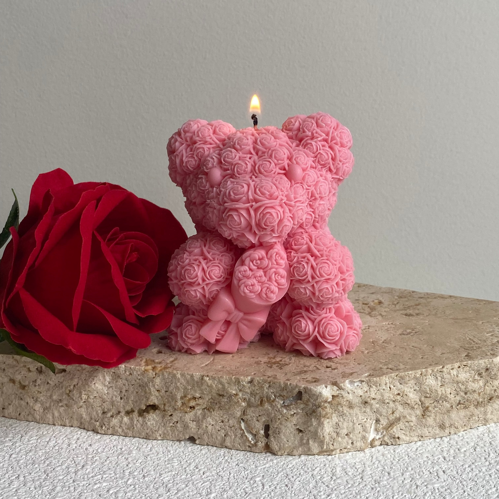 Pink teddy bear-shaped candle with a red rose on a stone surface | Pink Love Bear Sculptural candle