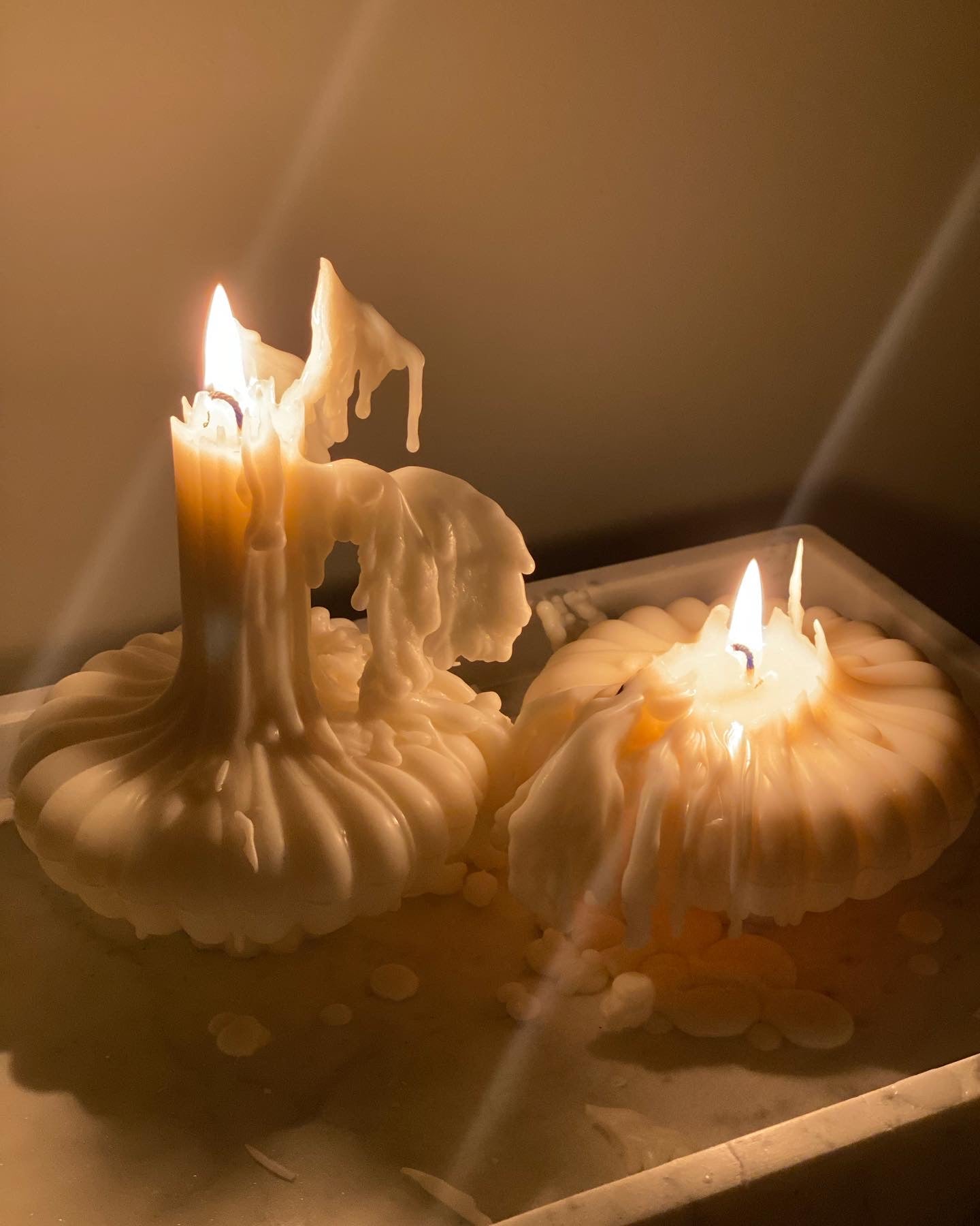 Sculptural candles lit and styled as decorative candles, showcasing wax transforming into soft sculptural forms.