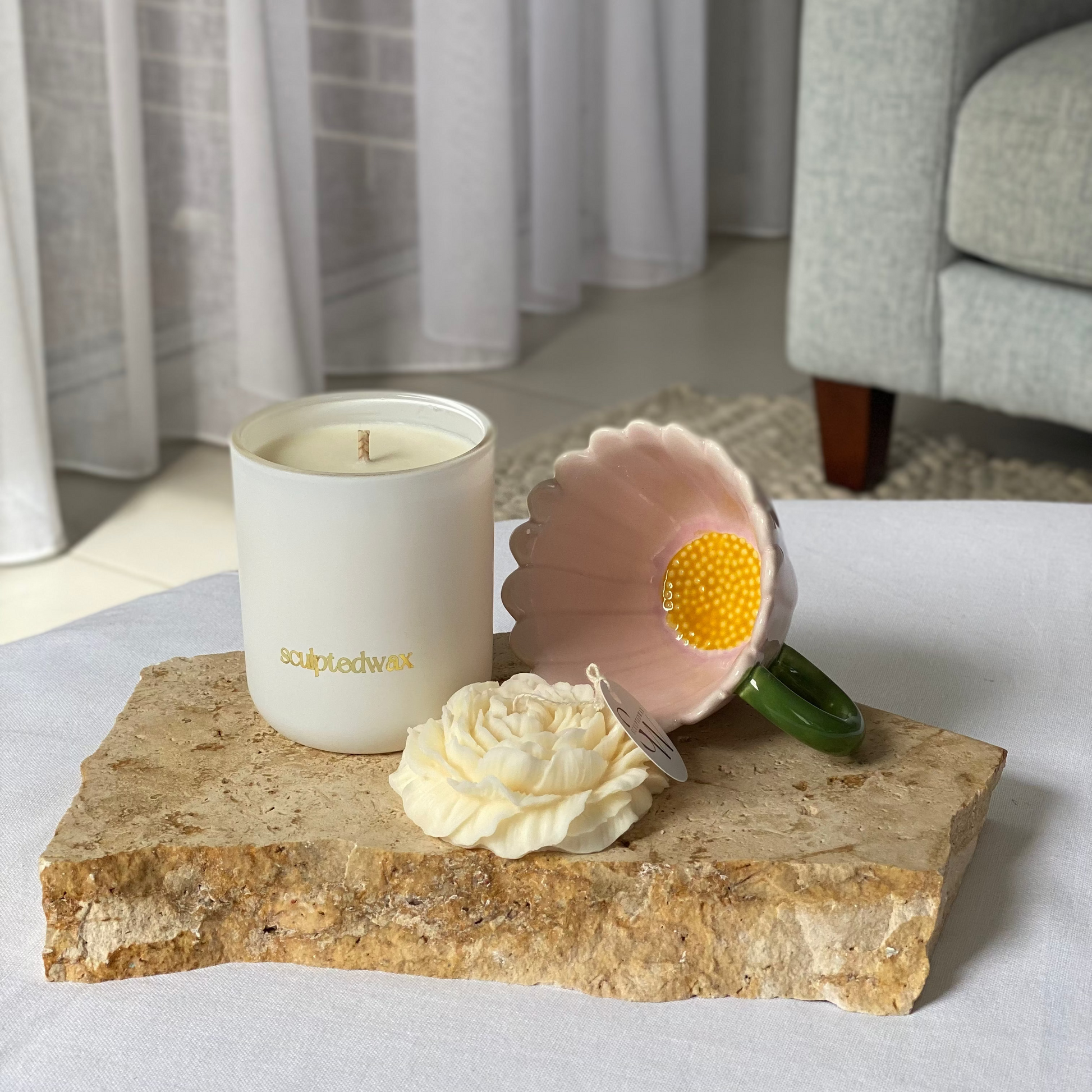 Pink sunflower mug being used for coffee in a slow morning routine, styled with candle for a calm home moment